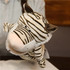 A plush tiger hand puppet with black and white stripes, featuring a soft, friendly face and small ears.