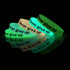 A set of glow-in-the-dark silicon wristbands in green and white with black text. They feature a motivational phrase.