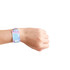 A multicoloured RPET fabric wristband with RFID card, featuring a logo, worn on a person's wrist.