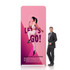 A straight tension fabric display wall in pink featuring a dynamic graphic and a person standing beside it.