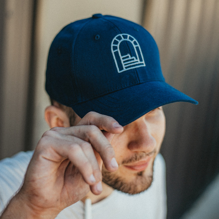 Six panel navy dad hat featuring white embroidery of the iconic Desert Door