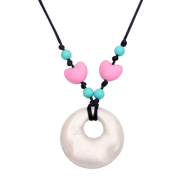 Soothe teething pains with the The Pencil Grip Silicone Teething Necklace. This necklace helps stimulate sensory development, and it's made of non-toxic silicone for safe usage.  Helps reduce pain from teething.  Stimulates sensory development.  Breakaway clasp offers safety.  Made of FDA approved non-toxic, food grade silicone.  Free of BPA and phthalates.  Heart pattern provides a fashionable look.