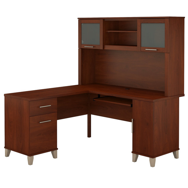 Make a professional statement and maximize your home office capabilities with the Somerset L Shaped Desk with Hutch. The beautiful and functional corner desk design includes a vertical storage cabinet for binders, manuals or supplies. This expansive workspace allows plenty of room to complete large projects and storage solutions to stay organized.  Bundle includes: L-Shaped Desk and Hutch.  Constructed of laminate over engineered wood.  Expansive surface provides plenty of room for computer, phone, printer and more.  Pull-out keyboard or laptop tray, pedestals and Hutch mount on left or right side for configuration flexibility.  Concealed storage cabinet for a computer tower or supplies, with rear wire access.  Box drawer stores office supplies.  File drawer glides on smooth ball bearing slides and accommodates letter-size documents.  Hutch has closed storage areas with lift-up frosted glass doors.  Open compartments in Hutch for books, binders or decorations.  Bush L Shaped Desk with Hutch Meets ANSI/SOHO test standards for safety.  Desktop weight capacity tested to support 200 lbs.  File drawers weight capacity tested to support 20 lbs.  Assembly required.  Standard Delivery Service. Furniture is delivered unassembled.  Backed by the Bush Furniture 6-Year Manufacturers Warranty. For additional information, please visit: www.bushfurniture.com/ReturnsExchanges  Assembled Dimensions: 59 1/6inW x 59 1/6inD x 64 1/2inH  This product is heavy and/or oversized and may need more than one person to handle.