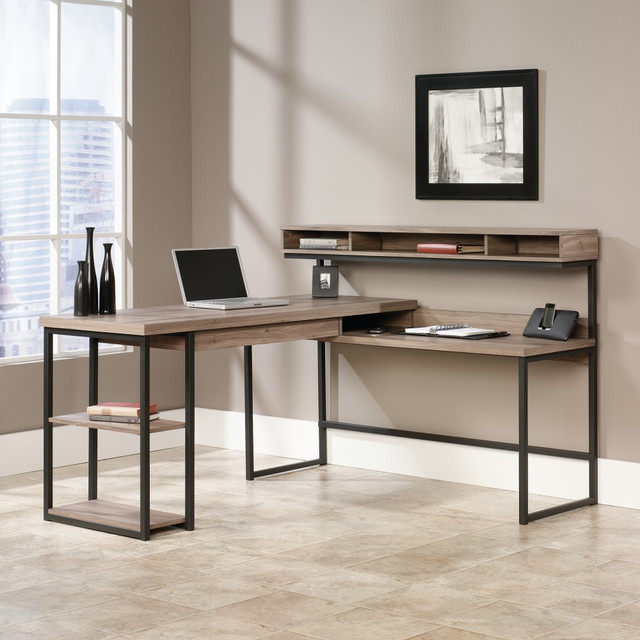 This Sauder L-shaped desk has everything you need to build a more organized desk space. Start your organizational goals on the right foot by adding this multi-level desk to your home office.  Sauder Transit Collection multi-tiered L-shaped desk design features storage cubbies and open shelves to help with your organizational strategy.  3 shelves and 1 drawer provide ample space to store files and more.  A raised monitor shelf lets you easily create an ergonomic setup.  Cord management helps keep your electronics clutter-free.  L-shaped desk comes in a salted oak finish.  This product is heavy and/or oversized and may need more than one person to handle.  Contains Recycled Content - See Specs for Details.