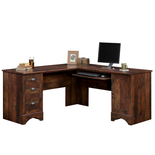 Great for getting work done, this computer desk is L-shaped to fit securely in a corner. The Sauder Harbor View collection corner desk is made from engineered wood for everyday use and features 3 drawers to help you keep files organized.  Sauder desk is made of engineered wood for lasting strength.  Generous surface helps you sort and organize paperwork.  Slide-out keyboard shelf is out of the way when not in use.  3 sliding drawers are ideal for filing.  Doors and drawers can be fastened to either the right or the left side.  Computer desk comes in a curado cherry finish.  Assembly required.  Slide-out keyboard/mouse shelf with metal runners and safety stops  Lower drawer holds letter or European size hanging files  Storage area behind door holds a vertical CPU tower and has an adjustable shelf for flexible storage options  Door and drawers can be fastened on the left or right side to fit your space best  Grommet hole for cord management allows a convenient path for cables and cords  Curado Cherry  This product is heavy and/or oversized and may need more than one person to handle.
