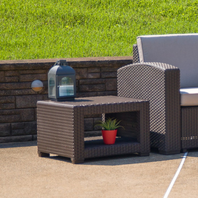 Take in the great outdoors with the Flash Furniture Seneca Faux Rattan Outdoor Furniture End Table. The table is made of resin for durability, and it sits on plastic block feet for stability. The open storage area is ideal for stashing magazines and books.  Made of resin.  Open storage.  Plastic block feet.  Unfinished.  Assembly required.  Backed by the manufacturer's 1-year limited warranty.