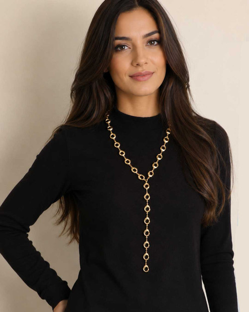 Sculpted Open Links Multi Style Necklace in gold worn as a lariat Y-drop by a model in a black turtleneck, front view