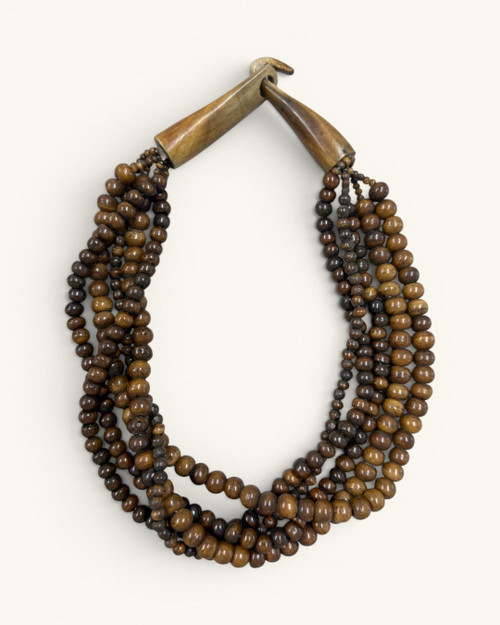 Brown five-strand beaded necklace laid flat on cream background, showing full shape and wooden toggle clasp