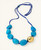 Cultural Elements blue tagua nut necklace with 24K gold plated pod and blue suede cord.