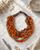 Honey hue twisted wood pendant necklace on marble surface