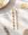 Dainty dangle earrings featuring multi-color tourmaline gemstones on marble background