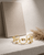 Brass cuff bracelet featuring oval moonstone and peach moonstone cabochons under dramatic spotlight lighting