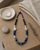 Hand-Painted Ceramic Bead Necklace with Metal Accents — necklaces, meditation corner lifestyle photo