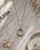 Rainbow Moonstone Circle Gold Plated Necklace — necklaces, editorial marble lifestyle photo