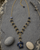 Indigo heart link necklace with blue gemstone pendant displayed on outdoor garden stone slate