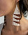 Beaded earrings with white and brown pattern worn by a person