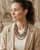 Cultural Elements multicolor layered necklace with five strands of textile beads and brass spacers.