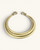 Hand-beaten brass triple-strand collar necklace on cream background, front view showing wire loop closures at each end