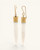 Bone spike dangle earrings with ridged brass caps standing upright, side view highlighting hook hardware and carved texture