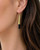 Tosha brass horn threader earring worn on model's ear, side profile showing gold cone and black horn drop against dark hair