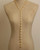 Sculpted Open Links Multi Style Necklace in gold in lariat style on dress form, highlighting the extended solid-link drop section, front view