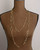 Brass link geometry long wrap necklace as single strand on dress form, front view showing full torso length