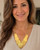 Hammered brass cascading disc necklace worn by a model in a white top, showing fit and drape at the neckline