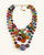 Kantha recycled textile four-strand statement necklace flat lay on white background, gold chain clasp visible at top