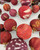 Close-up of kantha sari fabric-wrapped beads in red, maroon, and burgundy with mixed patterns and gold filigree connectors