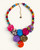 Kantha recycled textile layered bead necklace laid flat, showing multicolor fabric medallion pendant and beaded strand with gold clasp