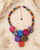 Kantha recycled textile layered bead necklace styled on a sandy surface with dried botanicals, showing full length with gold extender chain