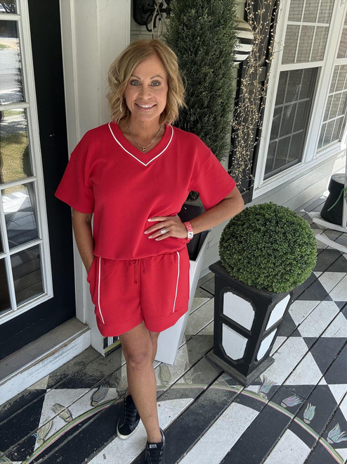 Woman posing in a red 2-piece set with shorts and shortsleeve