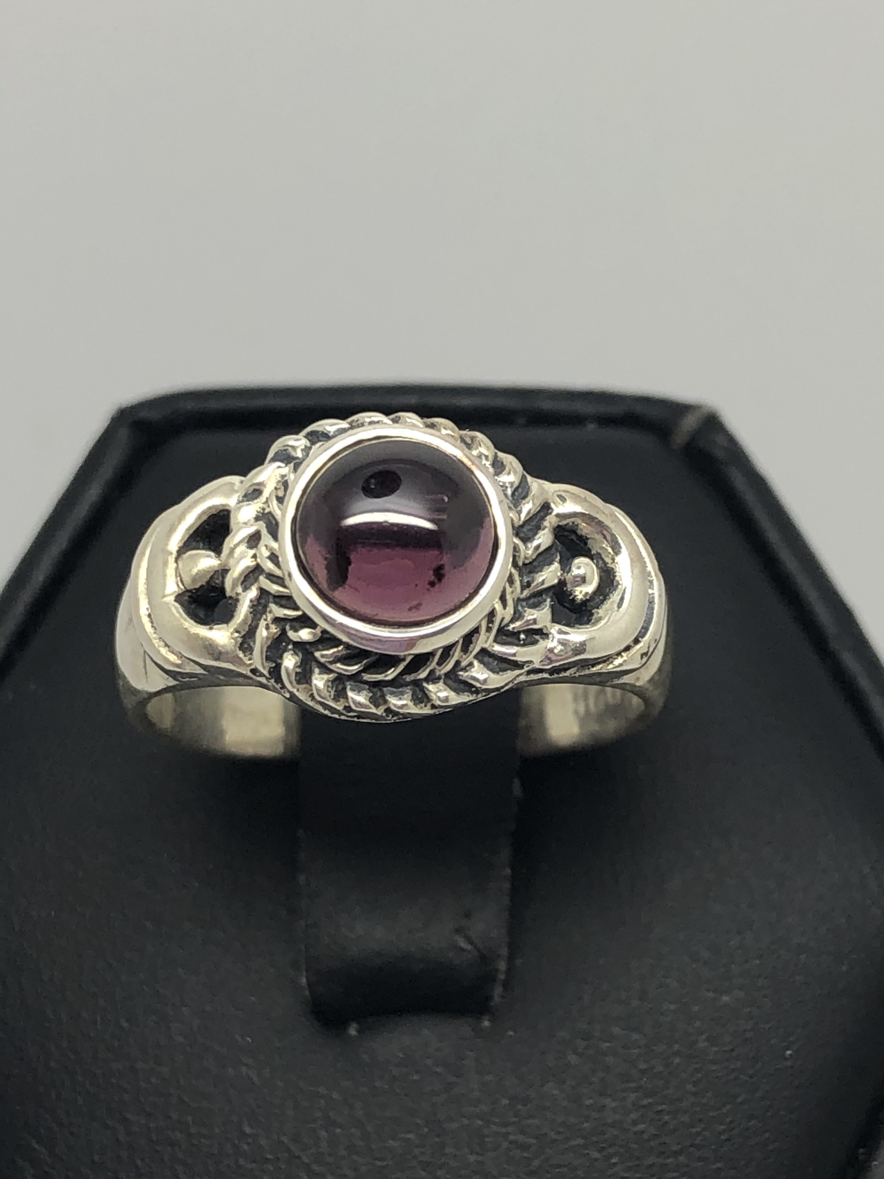 Ladies Sterling Silver ring with round garnet stone and rope design around stone