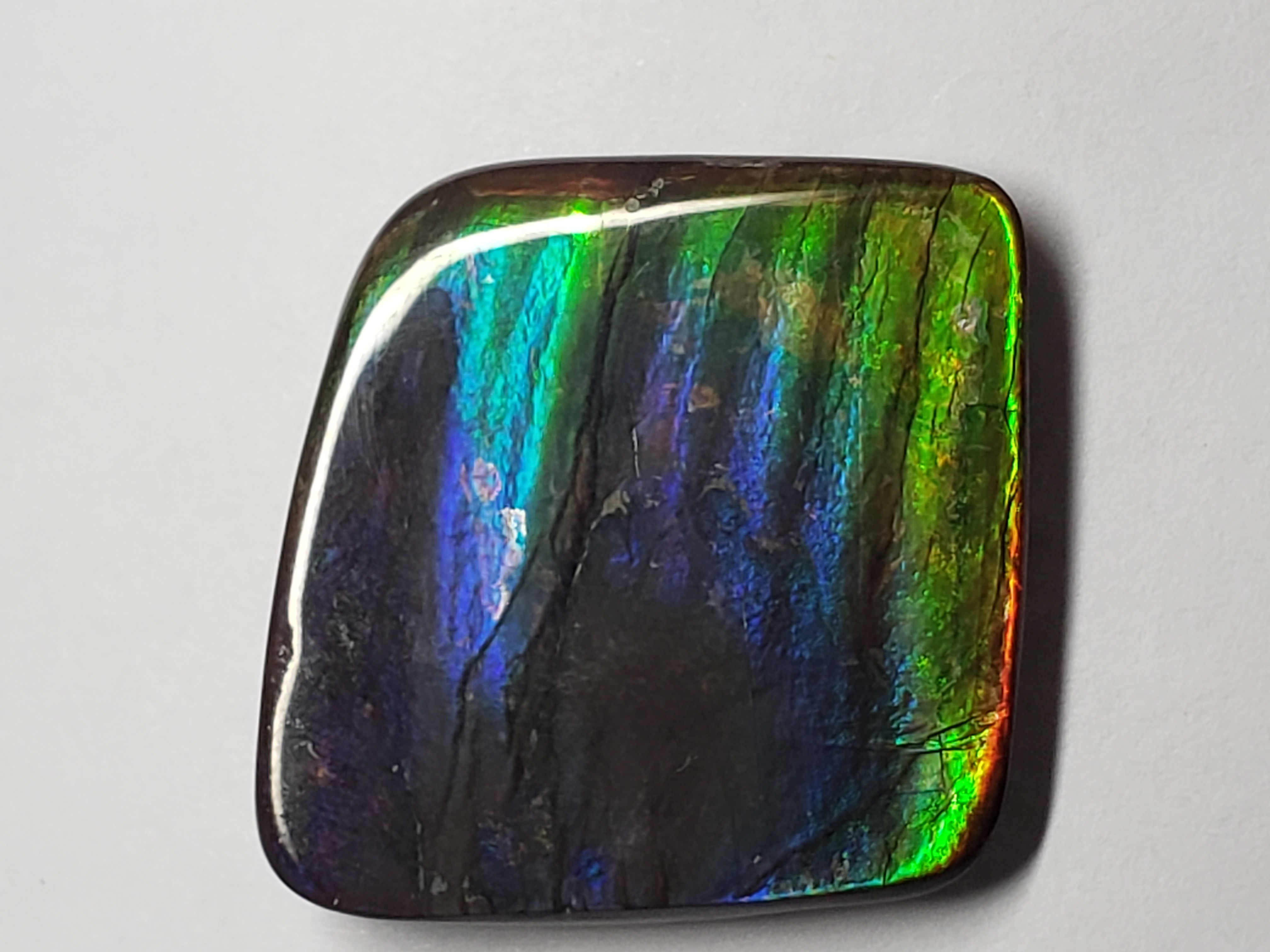 Capturing the essence of Ammolite's beauty in images proves challenging, as the colors dynamically shift in different lights. The mentioned color serves as a reference, with variations enhancing the stone's allure.