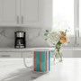White glossy mug with vibrant turquoise, orange and blue stripes on minimalist kitchen counter - coastal living aesthetic for everyday joy
