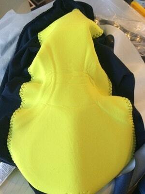 Bright yellow cycling chamois with ergonomic padding design, laid on a dark background