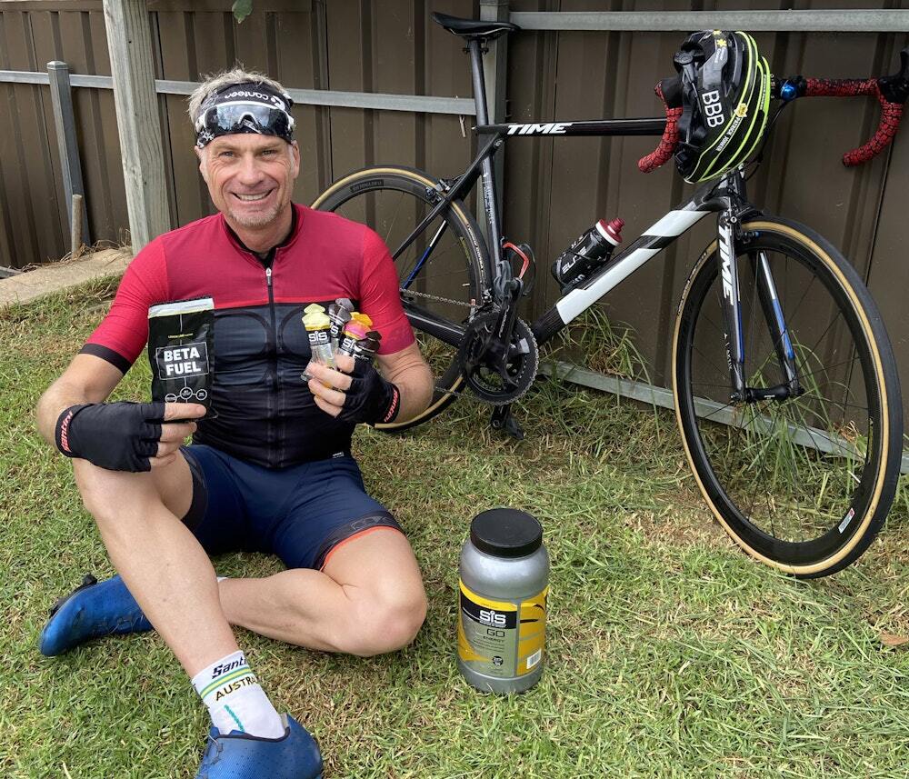 Cyclist sitting with SiS energy supplements and a TIME bike behind him
