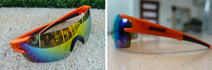 Two images of orange sports sunglasses with reflective multicolored lenses; one outdoors on concrete with grass, the other indoors on a countertop, showing the side profile with 'BBB' branding.