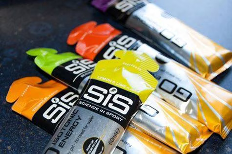 Colorful assortment of SiS Isotonic Energy Gels arranged on a table.