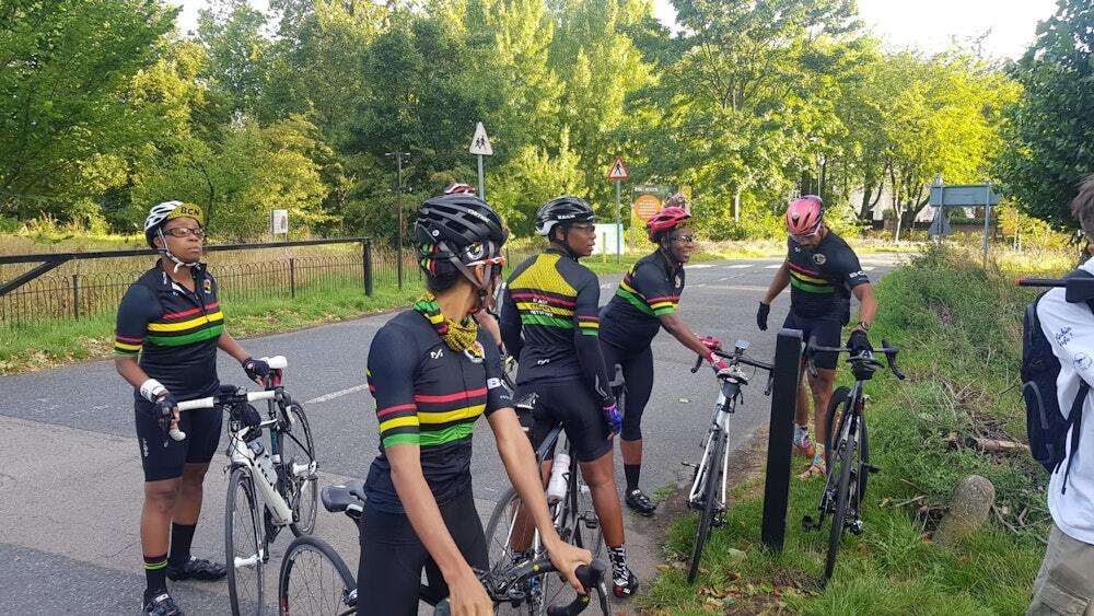 Group of cyclists in matching team kits with colorful stripes