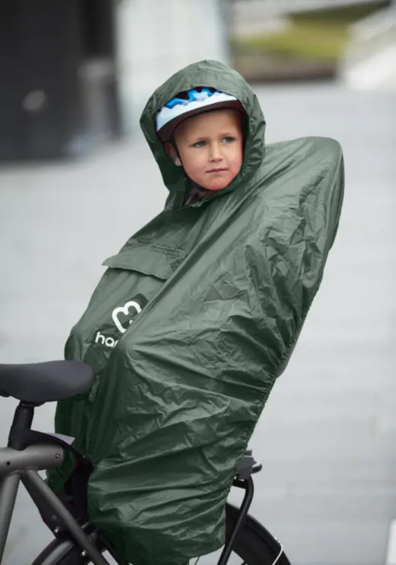 Hamax Amiga frame-mounted bike seat with rain poncho fitted to protect child from wind and rain