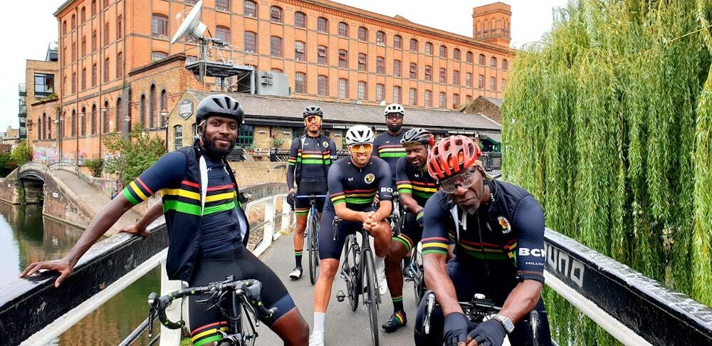 Scenic city backdrop while the team poses on a bridge with their bikes