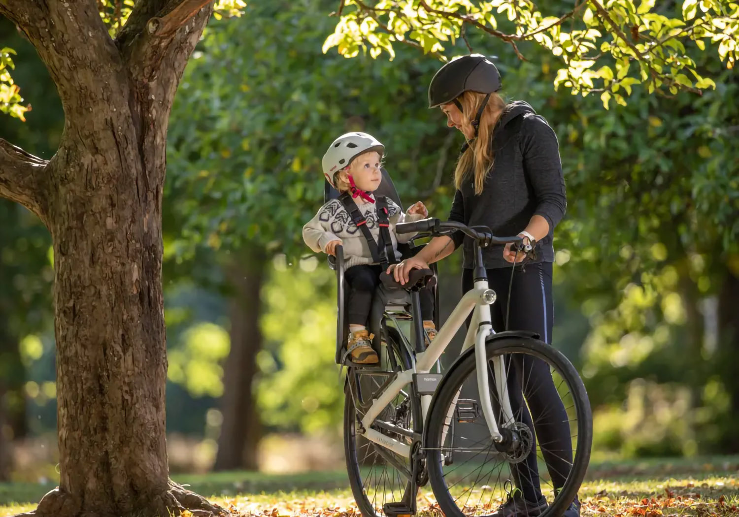 Parent cycling with child seated in Hamax Zenith Relax frame-mounted bike seat
