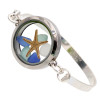 Genuine blue, aqua and white sea glass pieces with a real starfish in a stainless steel locket. Set on a solid sterling flat bangle bracelet.