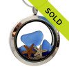 Blue sea glass pieces combined with a real starfish and beach sand in this sea glass locket necklace.