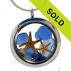 Blue sea glass pieces combined with a real starfish and beach sand in this sea glass locket necklace.