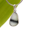 A very rare interesting piece of mutli color sea glass from Seaham England set in our Original Wire Bezel© setting.
A perfect black line is embedded inside this one of a kind pendant.