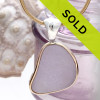 This sea glass is fused through with Vivid Purple or Lavender from Maine. It is set in a mixed metal gold and sterling silver Deluxe Wire Bezel setting. Very Versatile and elegant. CLASSIC!

This setting leaves this amazing natural sea glass piece just the way it was found on  the beach!