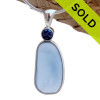 This beautiful Carolina or Periwinkle Blue sea glass piece is set in our Deluxe Wire Bezel© pendant setting with a sapphire lab created gem. Sorry this piece of Sea Glass Jewelry has been sold.