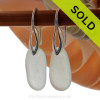 A pair of natural surf tumble sea glass earrings in a whitish green on sterling deco hooks